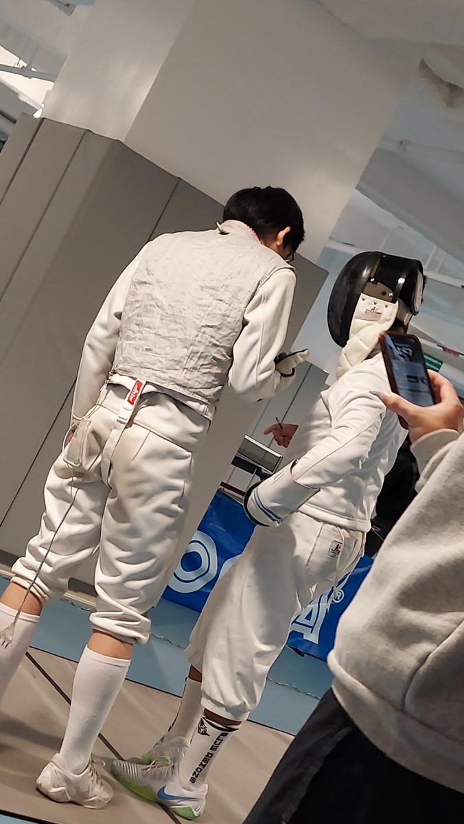 On Time-out, one of the fencing players giving advice to another starter.